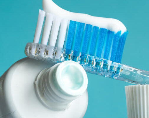 Eine Zahnbürste sowie Tube mit Zahnpasta, welche bei Herpes zu Entzündungen am Herpesbläschen führen kann.